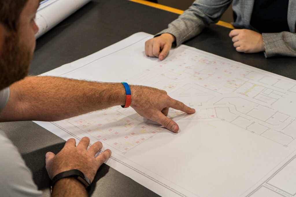 Two people analyzing a CTG blueprint at a table
