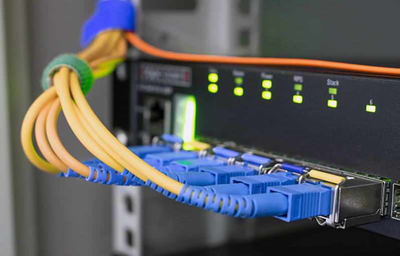 Fiber optic internet wires are connected to the ports of an access network switch