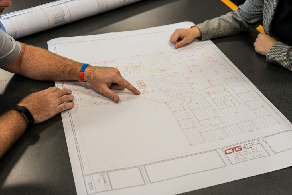 Two people analyzing a CTG blueprint at a table