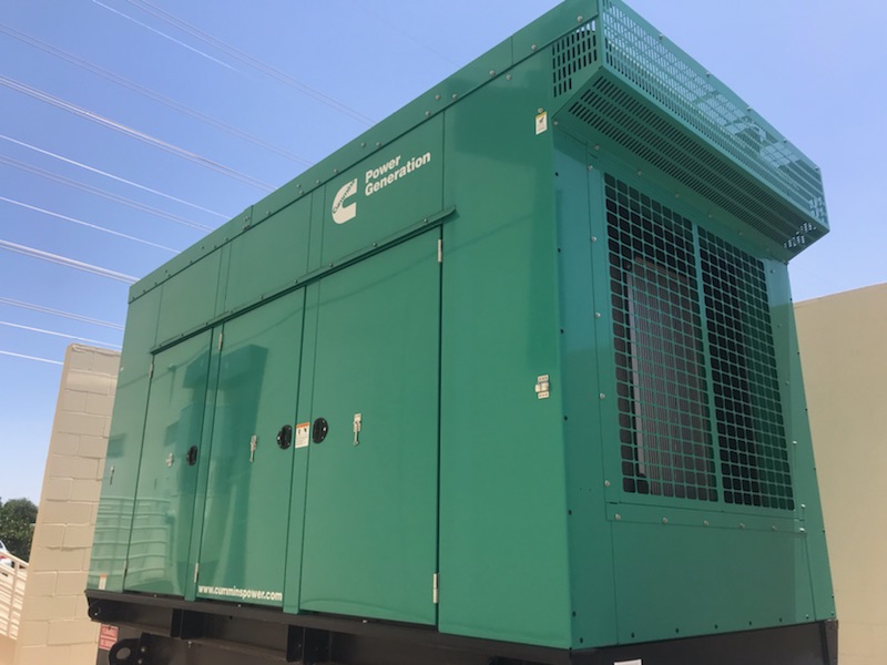 A large, green walk-in generator placed outside